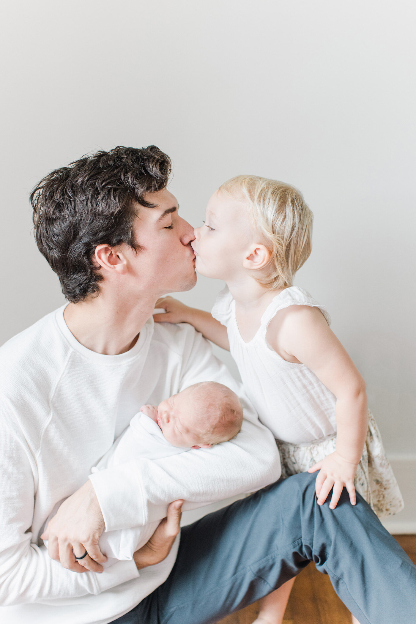 dad kissing toddler baby girl during newborn session