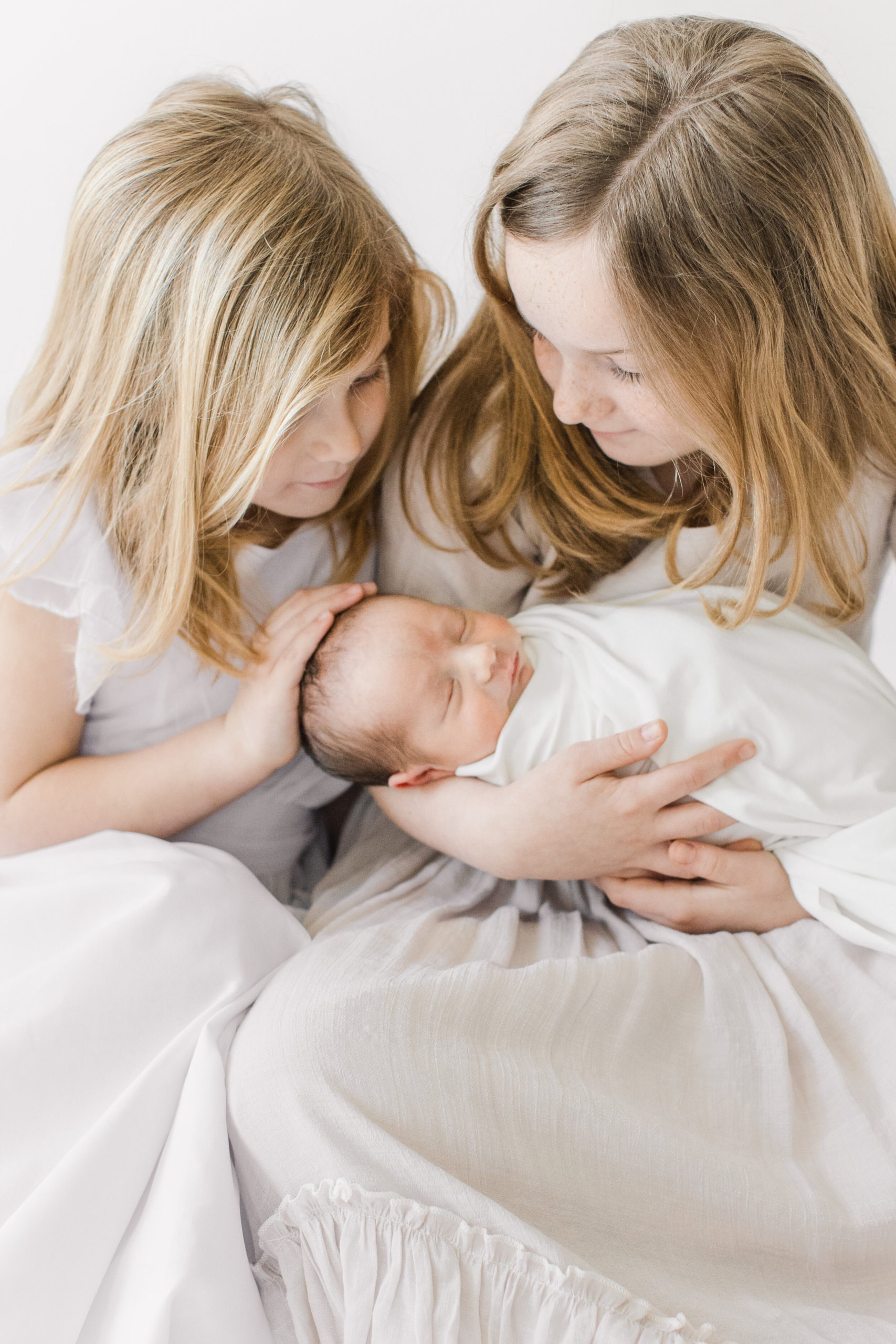 two older sisters with newborn baby